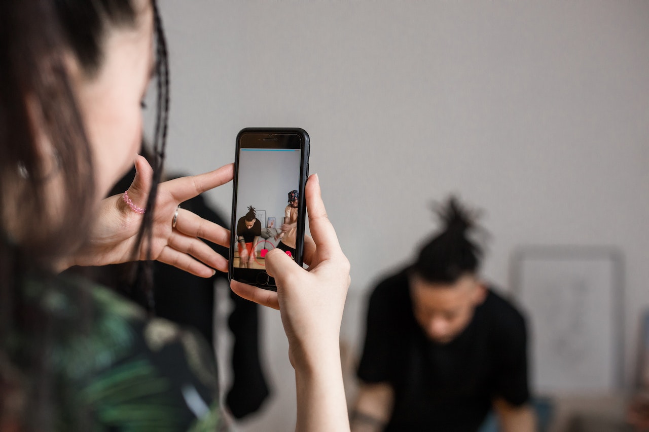 A person holding a smartphone and recording a video.